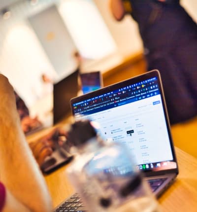 Ein Laptop und im Vordergrund eine Trinkflasche mit dem i22-Logo.